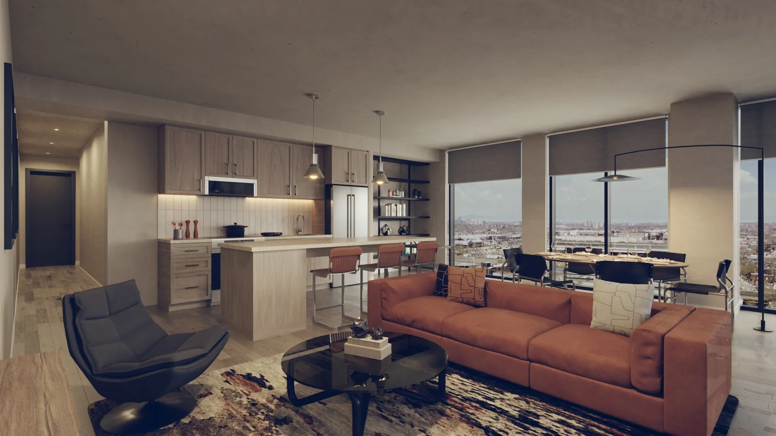 A three bedroom suite: an open living room with a rust sofa and a patterned rug beside a pale kitchen with an island and stools, floor to ceiling windows onto the city